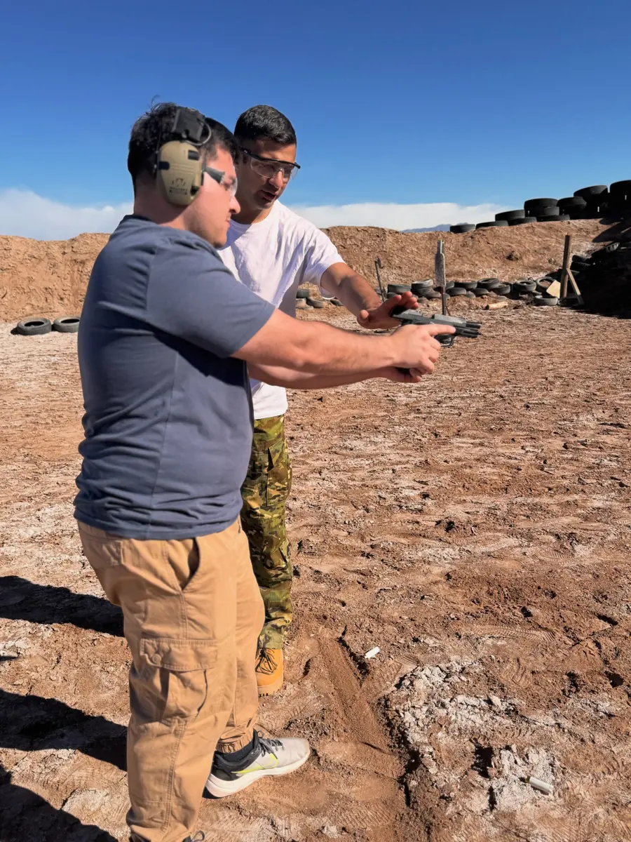 Instructor acompañando a un alumno en la línea de tiro